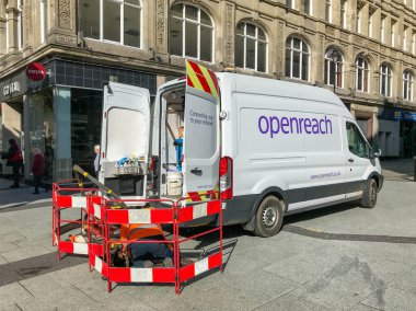 Cardiff, Galler - Mart 2019: Bt Openreach minibüsü Cardiff'te şehir merkezindeki bir caddeye park etti. Bir ajan bir ağ bağlantı noktasında engellerin arkasında çalışıyor.