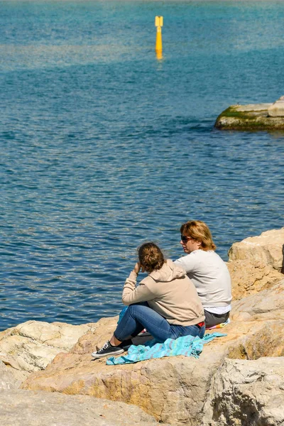 Due persone sedute sulle rocce che parlano a Cannes — Foto Stock