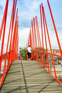 Bardolino, Garda Gölü, İtalya - Eylül 2018: Garda Gölü'ndeki Bardolino'daki küçük limanın girişindeyaya doğru yürüyen insanlar.