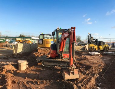 Birmingham, İngiltere - Mart 2018: İnşaat şantiyesindeki mini ekskavatörler