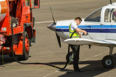 Cardiff Wales Airport, Galler - Temmuz 2018: Havaalanı önlüküzerinde park edilmiş yakıt tankeri ve Cardiff Wales Havaalanı'nda hafif bir uçağa yakıt ikmali yapmak üzere olan yakıt hortumu olan bir kişi