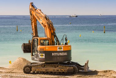 Cannes, Fransa - Nisan 2019: Cannes'daki plaja ilkbahar ve yaz tatili sezonuna hazır yeni kum lar ekleyen ekskavatör