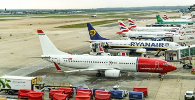 Londra Gatwick Havaalanı, İngiltere - Nisan 2019: Londra Gatwick Havaalanı'nın Güney Güney Terminali'nde arrriving sonra yer ekipmanları ile çevrili Norveç tarafından işletilen Boeing 737, arkasında diğer uçaklar ile.