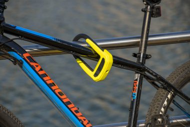 Swansea, Galler - Temmuz 2018: Hırsızlığı önlemek için bisikleti metal korkuluklara kilitleyen çelik kilidin yakından görünümü