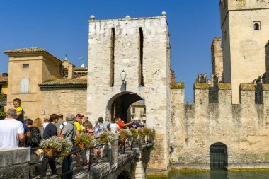 Sirmione, Garda Gölü, İtalya - Eylül 2018: İnsanlar eski şehir ve Scaliger Kalesi girmek için bir köprü geçerken. Garda Gölü'ndeki sirmione göl kenarındaki bir ortaçağ kalesidir..