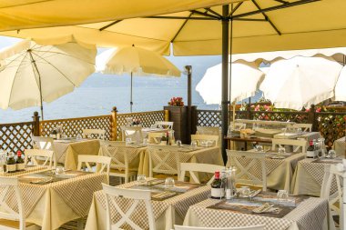 Torri Del Benaco, Garda Gölü, İtalya - Eylül 2018: Torri del Benaco'daki Garda Gölü'nün kenarındaki bir restoranda güneşin altında döşenmiş masalarla açık yemek alanı
