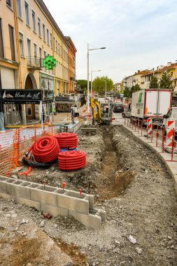 San Raphael, Fransa - Nisan 2019: San Raphael şehir merkezinde yapılan iyileştirmeler in bir parçası olarak kazılmış uzun bir siper arkasında Mini ekskavatör.