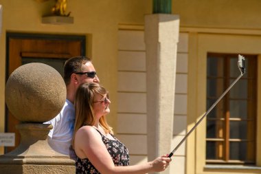 Prag, Çek Cumhuriyeti - Temmuz 2018: Prag Kalesi'nin bahçesinde selfie çeken iki kişi.