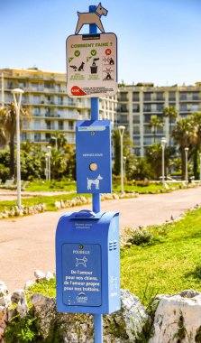 CANNES, FRANCE - APRIL 2019: Notice on the promenade in Cannes for dog owners to use bags to clean up after their dogs and place in the waste bine clipart