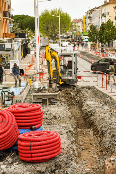 САН-РАФАЭЛ, ФРАНЦИЯ - Апрель 2019: Мини-экскаватор за длинной траншеей, вырытой в рамках усовершенствования центра города в Сан-Рафаэле
.
