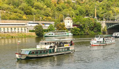 Prag, Çek Cumhuriyeti - Temmuz 2018: Prag'daki Vltava Nehri üzerinde nehir gezi teknelerini gezen turist. Nehir şehrin merkezinden geçer..