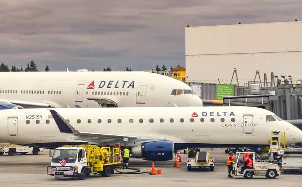 西雅图塔科马机场 2018年6月 Embraer 175通勤飞机在西雅图塔科马机场的地面包围地面处理设备 包括加油机 — 图库照片