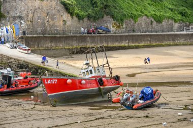 Tenby, Pembrokeshire, Galler - Ağustos 2018: Tenby, Batı Galler limanda topraklı kum düşük tide at üzerinde küçük balıkçı teknesi.