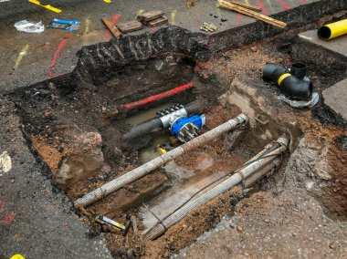 Pontypridd, Galler - Haziran 2019: Gaz borununa yeni bir vana takmak için yola büyük bir hendek kazıldı. Diğer yardımcı borular ve kablolar yol yüzeyinin altında görülebilir.