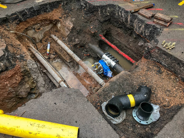 ПОНТИПРД, ИЮНЬ 2019: Большая траншея, вырытая в дороге для установки нового клапана в газопроводе. Другие коммунальные трубы и кабели можно увидеть под поверхностью дороги
.