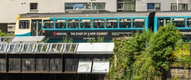Cardiff, Galler - Haziran 2019: Cardiff şehir merkezinde bir köprüden geçen Galler için Ulaşım geçici livery banliyö treni