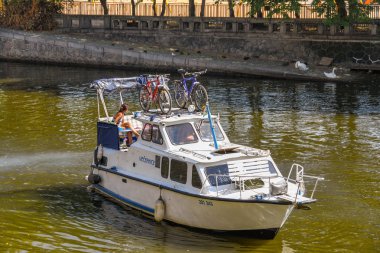 Prag, Çek Cumhuriyeti - Temmuz 2018: Prag şehir merkezinde Vltava Nehri üzerinde motorlu tekne. Bir çift bisiklet teknenin üstünde saklanır..