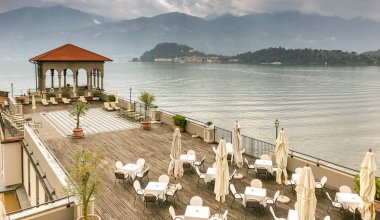 LAKE COMO, ITALY - JUNE 2019: Outdoor dining area on the roof top of the Grand Hotel Cadenabbia on Lake Como. clipart
