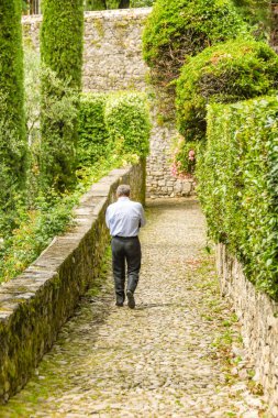 Como Gölü, İtalya - Haziran 2019: Greenway del Lago di Como güzergahı üzerinde bir narrrow arnavut kaldırımlı yolda yürüyen kişi.
