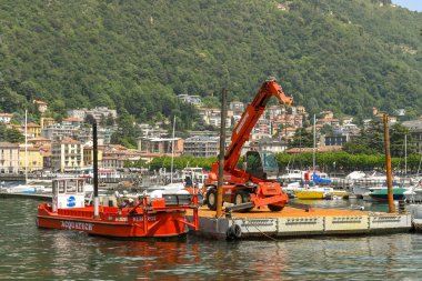 Como Gölü, İtalya-Haziran 2019: Como Gölü üzerinde Como limanında Teleskopik kaldırma traktör vinç ile endüstriyel mavna ve duba.