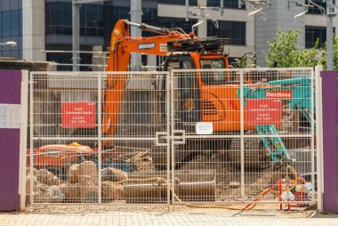 Cardiff, Galler - Temmuz 2019: Cardiff şehir merkezindeki bir şantiyeye giriş. Kapının arkasında hidrolik bir ekskavatör var..