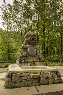 Craigellachie, British Columbia, Kanada - Haziran 2018: Kanada Pasifik Demiryolu'nu tamamlamak için son demir çivisinin raylara dövüldüğü yerdeki taş anıt