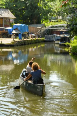 Bath, İngiltere - Temmuz 2019: Bath kenti yakınlarındaki Somerset Kömür Kanalı'nda kano yla kürek çeken insanlar