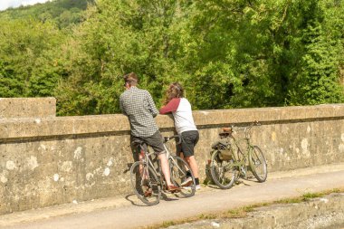 Bath, İngiltere - Temmuz 2019: Bisikletçiler bir mola ve Bath kenti yakınlarındaki Kennet & Avon Kanalı üzerinde Dundas Aquaduct duvarına bakan
