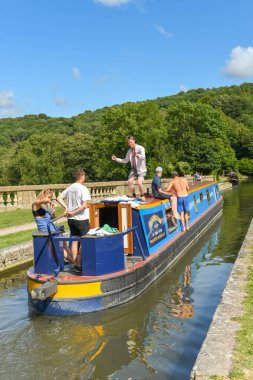 Bath, İngiltere - Temmuz 2019: Bath kenti yakınlarındaki Kennet & Avon Kanalı'ndaki Dundas Aquaduct üzerinde seyreden insanların olduğu dar tekne