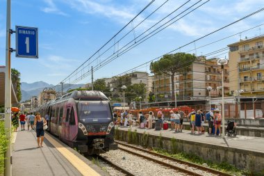 Sorrento, İtalya - Ağustos 2019: İstasyonda tren ve sorrento tren istasyonunda bir platformüzerinde bir tren inmek için bekleyen kalabalık.