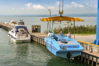 Bardolino, Garda Gölü, İtalya - Eylül 2018: Bardolino yakınlarındaki Garda Gölü'ndeki bir marinada sürat teknesi nin suya indirilmesi.