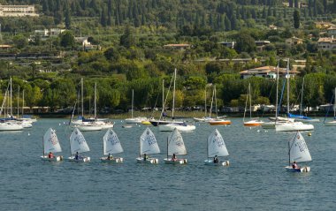 Bardolino, Garda Gölü, İtalya - Eylül 2018: Garda Gölü'ndeki Bardolino'da yelken kursuna katılan dinghies'deki çocuklar.