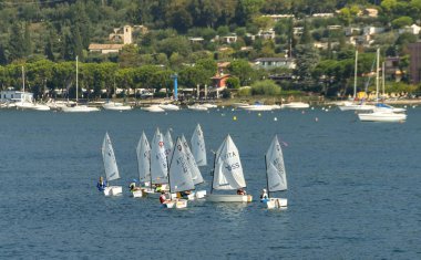 Bardolino, Garda Gölü, İtalya - Eylül 2018: Garda Gölü'ndeki Bardolino'da yelken kursuna katılan dinghies'deki çocuklar.