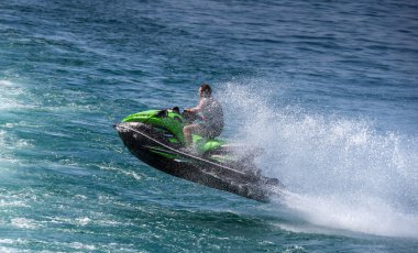 Garda Gölü, İtalya - Eylül 2018: Jet ski ve binici Garda Gölü'nde bir dalga atladıktan sonra sprey le kaplı.