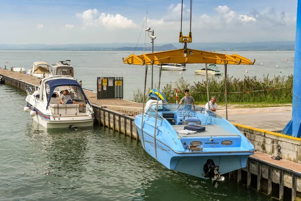Bardolino, Garda Gölü, İtalya - Eylül 2018: Bardolino yakınlarındaki Garda Gölü'ndeki bir marinada sürat teknesi nin suya indirilmesi.