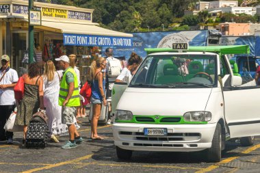 Isle Of Capri, İtalya - Ağustos 2019: Bir feribotla geldikten sonra Capri Adası'ndaki limanda taksi durağında bagajı olan kişiler.