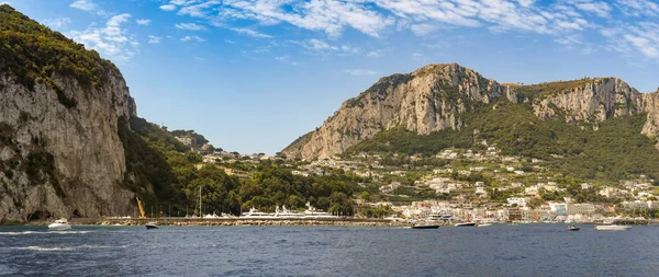 Isle Of Capri, İtalya - Ağustos 2019: Arkasında dağlar olan Capri adasındaki limanın panoramik manzarası.