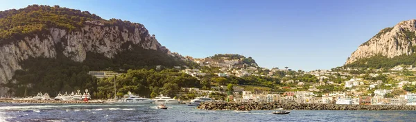 Isle Of Capri, İtalya - Ağustos 2019: Arkasında dağlar olan Capri adasındaki limanın panoramik manzarası.