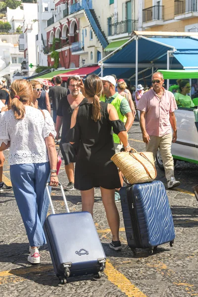 Isle Of Capri, İtalya - Ağustos 2019: Bir feribotla geldikten sonra Capri Adası'ndaki limanda taksi durağında bagajı olan kişiler.