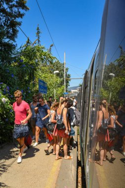 Pompeii, Napoli yakınlarında, İtalya - Ağustos 2019: Diğerleri çıkışa giden platform boyunca yürürken insanlar Pompeii Scavi istasyonunda trene biniyor