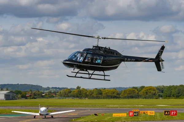 英国格洛斯特 2019年9月 贝尔杰杰兰格由赫利 飞行在格洛斯特斯塔弗顿机场降落 背景A是轻型飞机滑行起飞 — 图库照片
