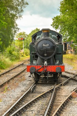 Cranmore, İngiltere - Temmuz 2019: Doğu Somerset Demiryolu'ndaki Cranmore İstasyonu'na yaklaşan restore edilmiş bir buhar makinesinin görünümüne doğru.