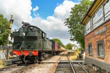 Cranmore, İngiltere - Temmuz 2019: Doğu Somerset Demiryolu'ndaki Cramore İstasyonu'nda lokomotifin kömür ihalesine tırmanan buharlı motor itfaiyecisi.