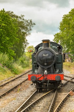 Cranmore, İngiltere - Temmuz 2019: Doğu Somerset Demiryolu'ndaki Cranmore İstasyonu'na yaklaşan restore edilmiş bir buhar makinesinin görünümüne doğru.