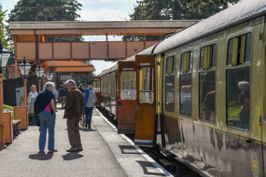 Gloucestershire, İngiltere - Eylül 2019: Gloucestershire ve Warwickshire Demiryolu'ndaki Broadway istasyonunun platformundaki insanlar. Platformda bir tren bekliyor..