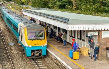Abergavenny, Wales - Eylül 2019: Abergavenny tren istasyonuna gelen banliyö treni. İnsanlar platformda bekliyor..