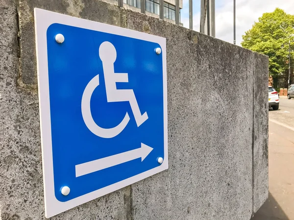 CARDIFF, WALES - JULY 2019: Close up viiew of a sign showing the way to an access ramp for disabled persons.