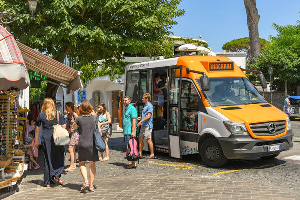 ANACAPRI, ISLE OF CAPRI, ITALY - AUGUST 2019: People getting off a bus in the town of Anacapri on the Isle of Capri. Small buses are used on the island due to the narrow roads.