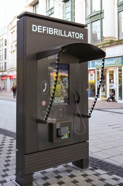CARDIFF, WALES - HAZİRAN 2020: Cardiff şehir merkezinde halka açık bir telekonferans kabininde bir defibrilatörün yerini gösteren imza
