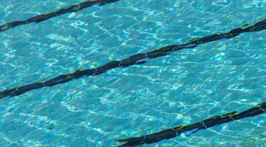 Şablonlar, sabah güneşiyle birlikte açık yüzme havuzunda suyun üzerinde şekillendi.